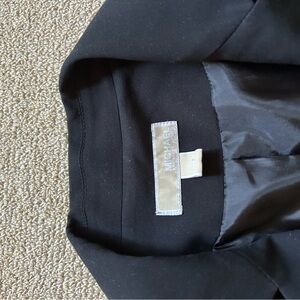 Black, Michael Cors blazer. Fringed at the 3/4 sleeves. Iron stain on one sleeve